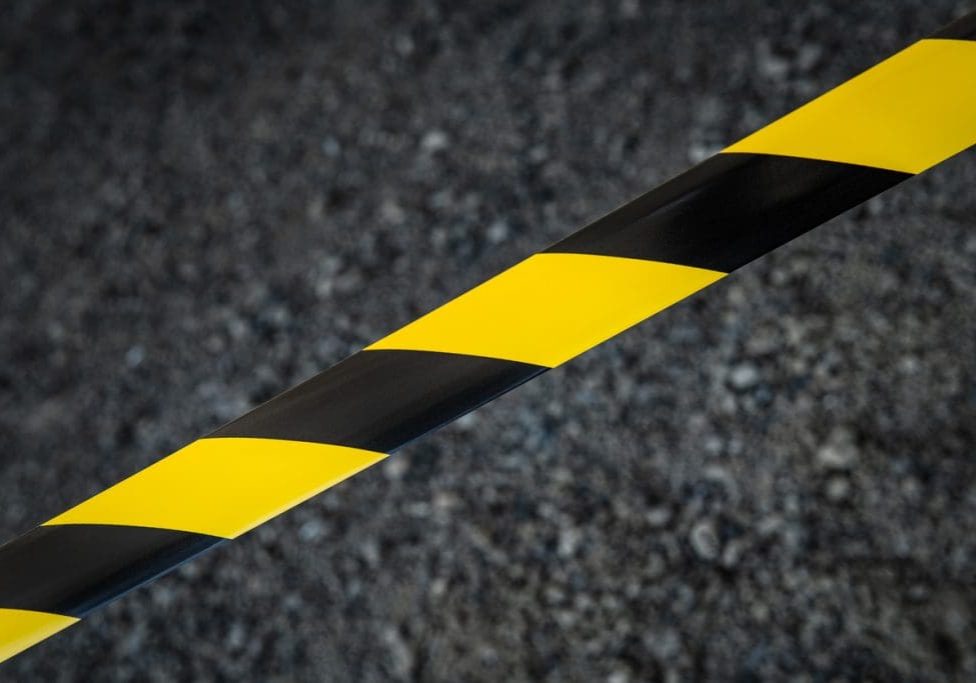 Black and yellow striped tapes on dark background. Restricted area border. Passage is forbidden.