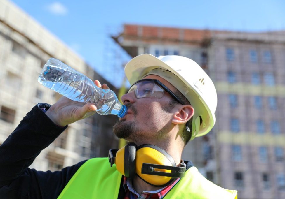 boss at construction site with bottle of water, close up