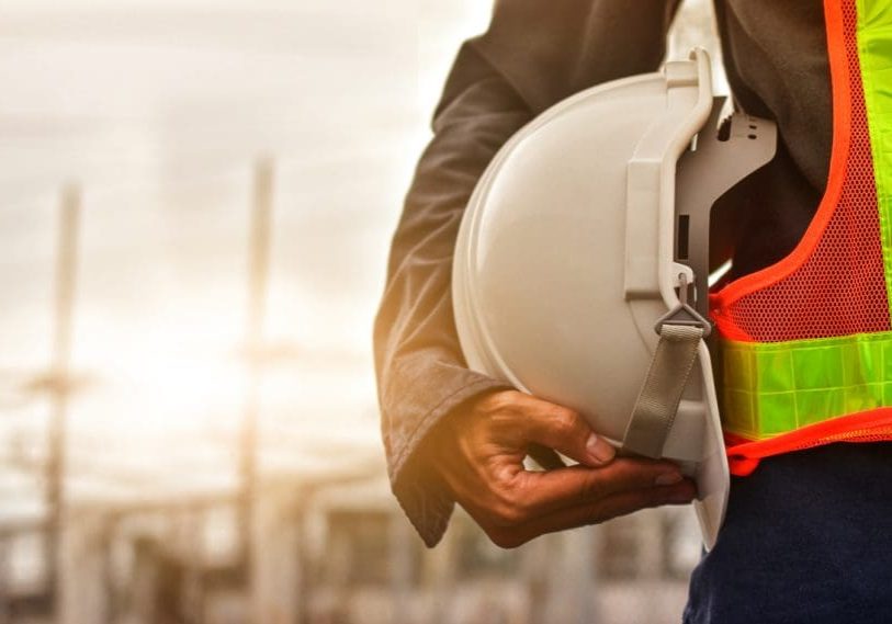 Technician holding white hat safety hard hat sunlight background