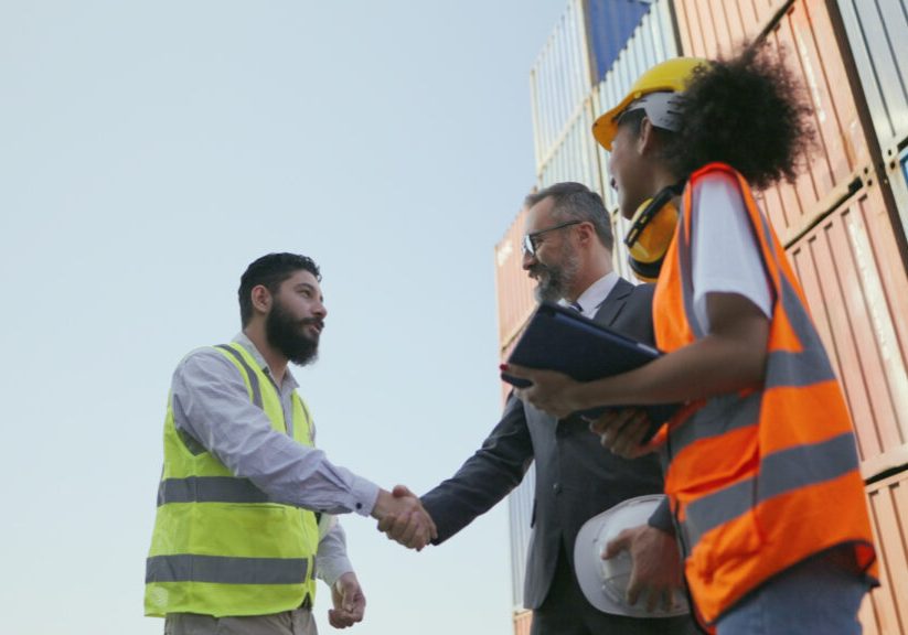 Businessman or investor and engineer handshake, talking happily after corporate partnership deal successful, have investment and employment. Multiracial partners working together in logistics business.