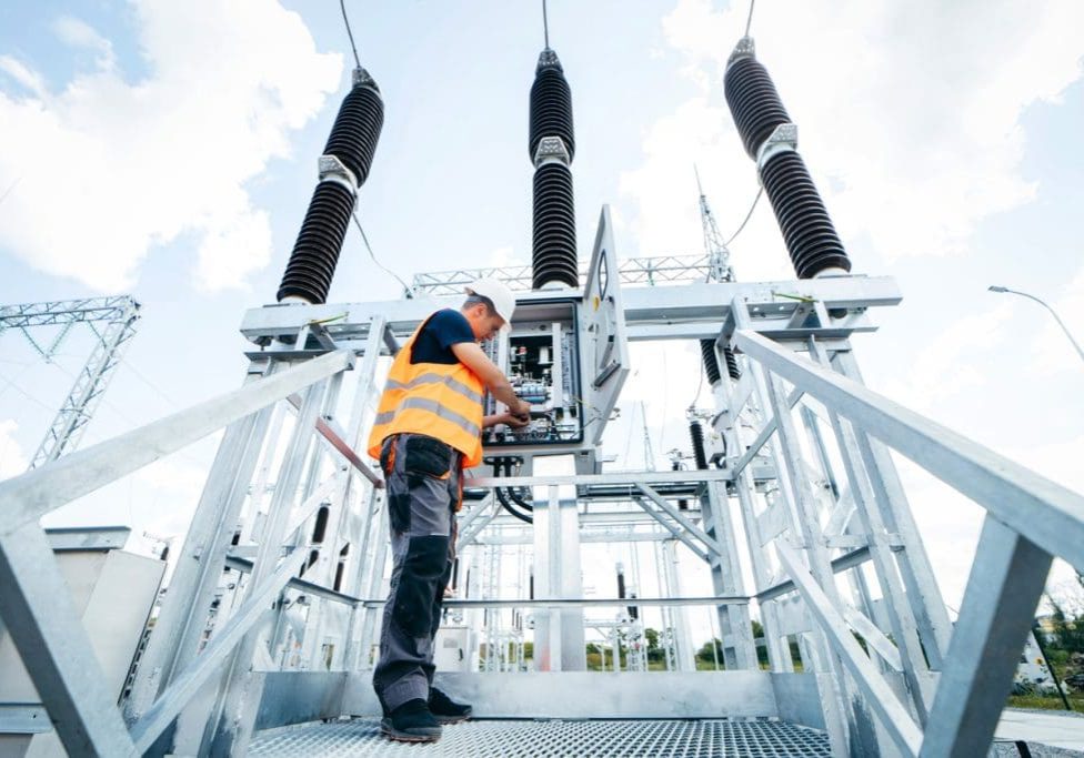 Adult electrical engineer inspect the electrical systems at the equipment control cabinet. Installation of modern electrical station