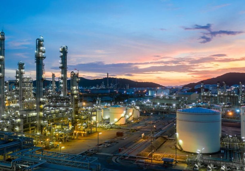 Aerial view oil and gas tank with oil refinery background at night, Glitter lighting of petrochemical plant with night, Manufacturing of petroleum, Products tank in petrochemical plant.