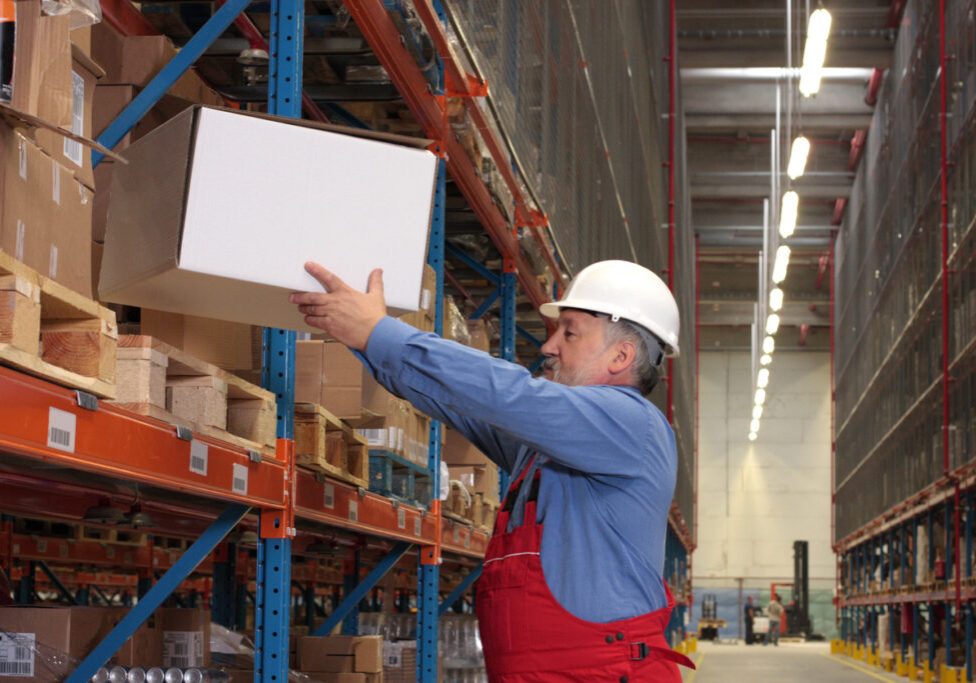 worker  putting box on  shelf in warehouse